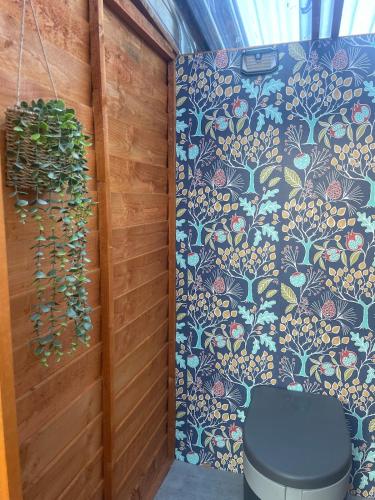 a bathroom with a toilet and a plant on a wall at Digital detox unplugged retreat in Southam