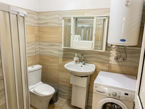 a bathroom with a toilet sink and a washing machine at Lake of Diber in Debar