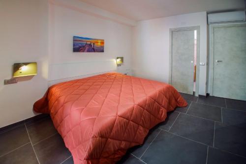 a bedroom with a bed with a red comforter at El Bahia Gaeta in Gaeta