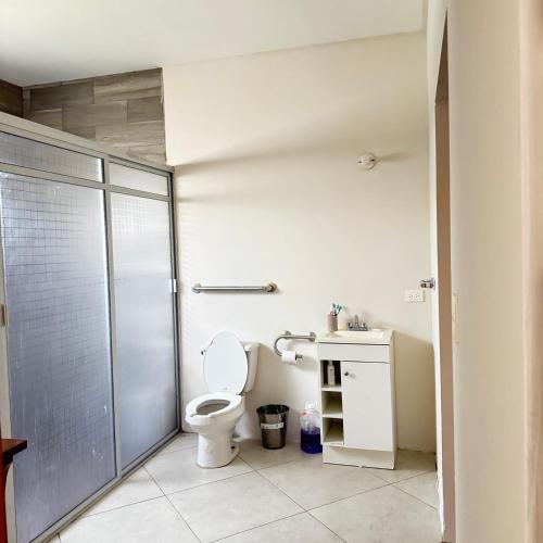 a bathroom with a toilet and a glass shower stall at Casa el palmar in Guaymas