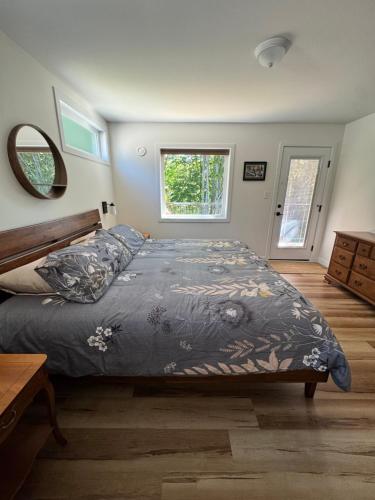 a bedroom with a bed with a blue comforter at Harbourview Hideaway Sooke in Sooke