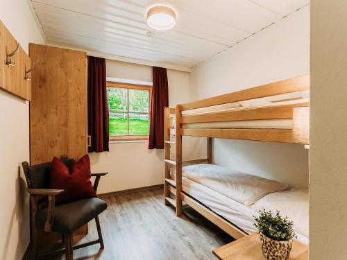 ein Zimmer mit zwei Etagenbetten und einem Stuhl in der Unterkunft Barney M in Rauris