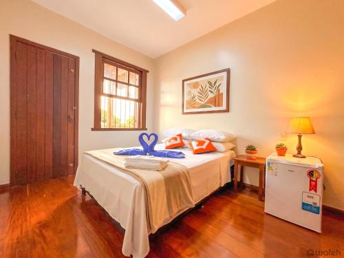 a bedroom with a bed with a blue ribbon on it at Wafeh Guest House - Fleming - Bar & Jardim in Belo Horizonte
