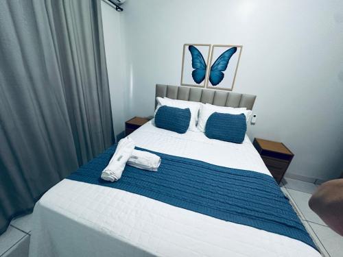 a bedroom with a large bed with blue pillows at Aconchego e praticidade in Mineiros
