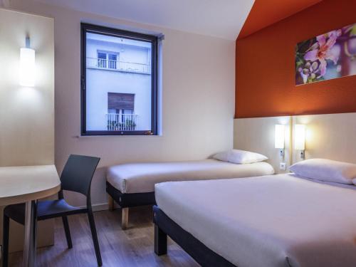 a hotel room with two beds and a window at ibis budget Cannes Centre Ville in Cannes