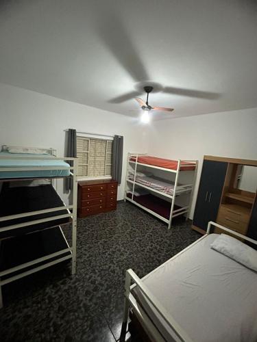 a room with three bunk beds and a ceiling at Residencial Parque Santa Bárbara in Campinas