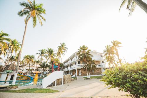 a resort with a slide and palm trees at Marea by Mar Paraiso Queen in Acapulco