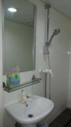 a bathroom with a white sink and a mirror at Le Cong Fraternal Guest House in Hong Kong