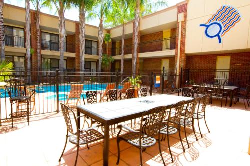 a table and chairs in front of a building with a pool at Wentworth Grande Resort in Wentworth