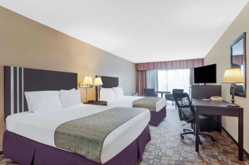 a hotel room with two beds and a desk at FairBridge Inn Express Bellingham in Bellingham