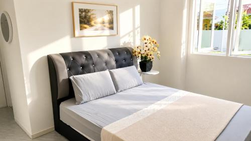 a bed with a black headboard in a room at Villa Ar Raudhah Kuala Terengganu in Kampong Cherong Baru