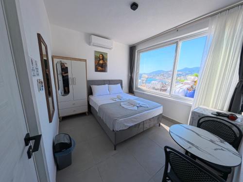 a small bedroom with a bed and a large window at Merhaba Pansiyon in Bodrum City