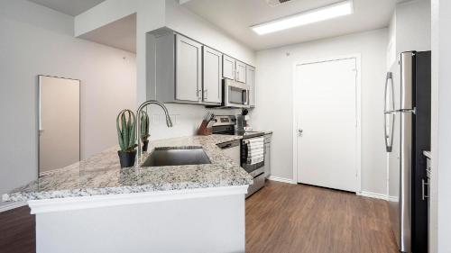 a kitchen with a sink and a refrigerator at Landing Spectacular 1BD Pool Gym in San Antonio