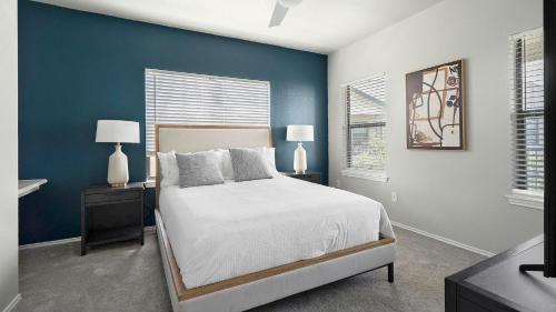 a bedroom with blue walls and a bed with two lamps at Landing Spectacular 1BD Pool Gym in San Antonio