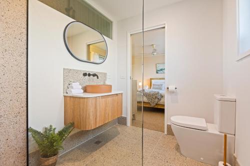 a bathroom with a sink and a toilet and a mirror at The Crows Nest Eden in Eden