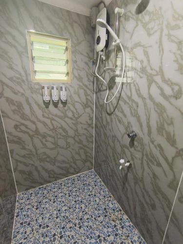 a bathroom with a shower with a shower head at LG Palms in Sigatoka