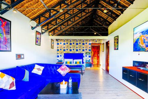 a living room with a blue couch and a table at Kitumo Mara Lodges in Mara Simba
