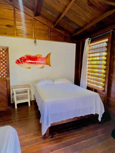 a bedroom with a bed and a fish on the wall at LOTO'S House in West End