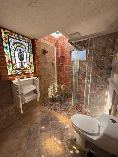 a bathroom with a shower and a toilet and a stained glass window at Jardin Quinta las Fuentes in Santo Tomás Chautla