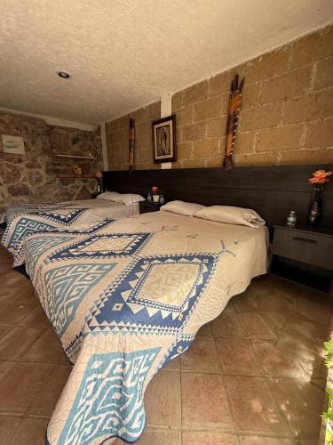 a bedroom with two beds and a brick wall at Jardin Quinta las Fuentes in Santo Tomás Chautla