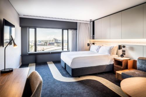 a hotel room with a bed and a desk at Crowne Plaza Auckland by IHG in Auckland