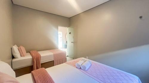 a room with two beds with towels on them at Rosa Serena - Conforto, silêncio e garagem - Casa com 2 quartos, próximo a rodoviária e aeroporto in Palmas