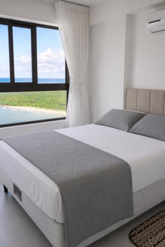 a bedroom with a large bed and a large window at Paiva Ocean View - 17th Floor with Pool, Sauna & Jacuzzi in Recife