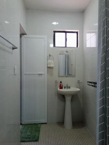 a white bathroom with a sink and a shower at Casa Lomalinda in Miahuatlán de Porfirio Díaz