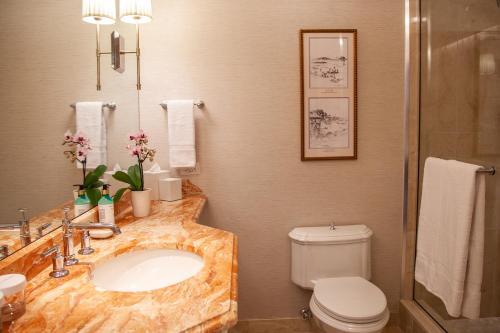 a bathroom with a marble sink and a toilet at Delamar Greenwich Harbor in Greenwich