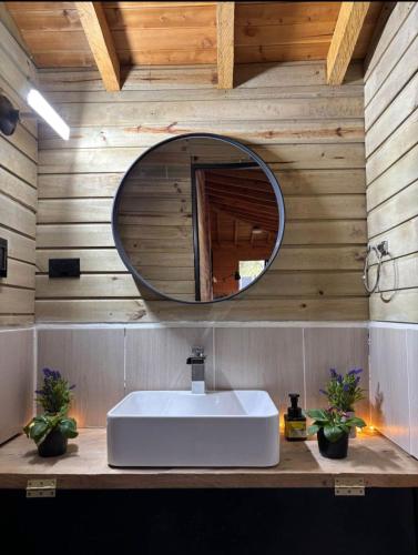 a bathroom with a white sink and a mirror at Cabaña del Sol in Medellín