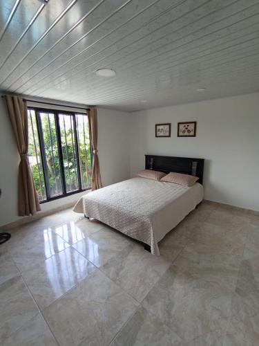 a bedroom with a bed and a large window at Hospedaje La Tebaida in La Tebaida