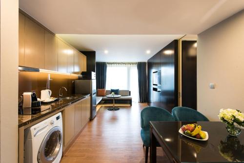 a kitchen and living room with a washer and a table at Novotel Suites Hanoi in Hanoi