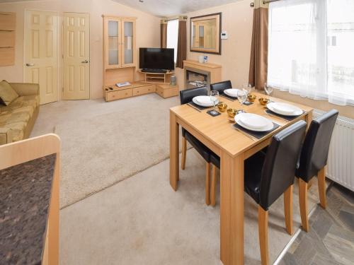 a living room with a wooden table and chairs at Fellside Lodge in Cockermouth