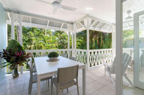 a white dining room with a table and chairs at Villa 8 on Murphy Prime Location & Lifestyle in Port Douglas