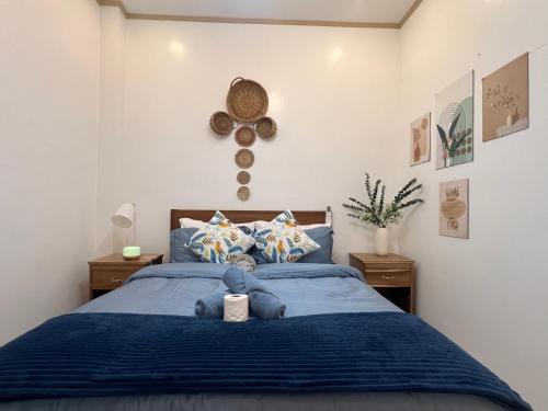 a bedroom with a blue bed with a clock on the wall at A-rena Homestay in General Luna
