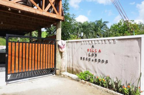 a gate to a building with a sign on it at villa los recuerdos in Jarabacoa