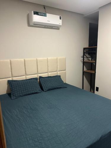 a bedroom with a bed and a air conditioner on the wall at D Castro Art House in Montes Claros