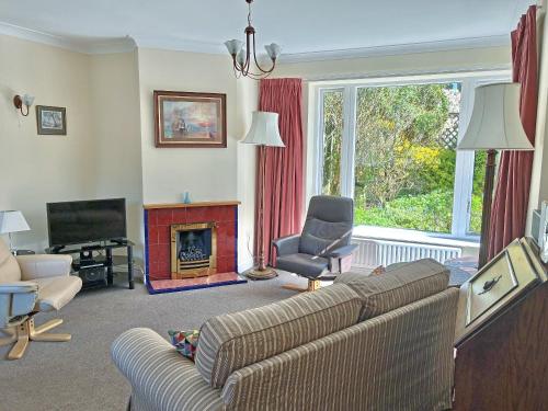 a living room with a couch and a chair and a fireplace at Belgravia Cottage in Skipton