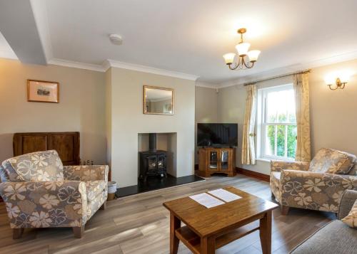 a living room with two chairs and a coffee table at Green Acres Cottages in Par