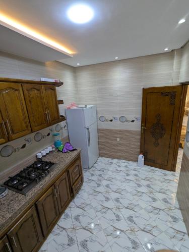 a kitchen with a stove and a white refrigerator at House apartment in Tangier