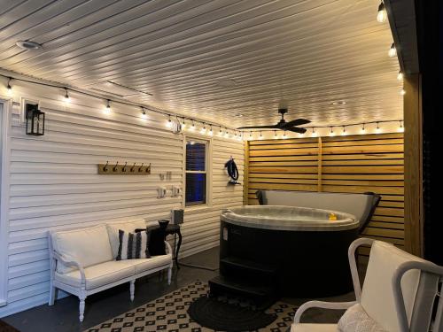 a bathroom with a tub and a couch and a chair at Meme & Papas Compound 2 Homes, Hot Tub in Afton