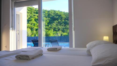 a bedroom with a large bed with towels on it at Villas Magnolia in Blagaj