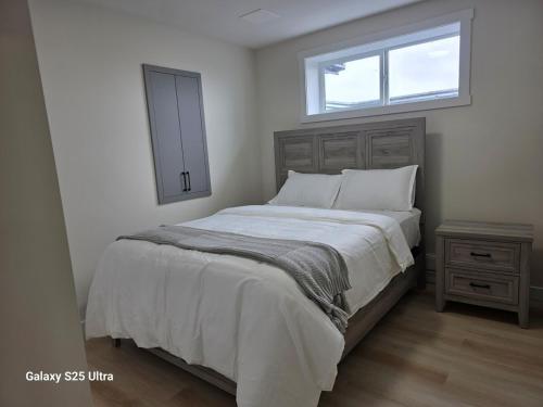 a bedroom with a large bed and a window at Executive Luxury Suite Unit B in Regina