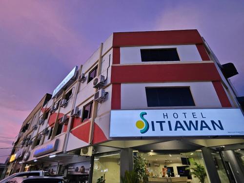 a hotel with a sign in front of a building at Hotel Sitiawan in Sitiawan