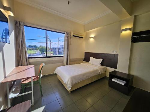 a small bedroom with a bed and a window at Hotel Sitiawan in Sitiawan