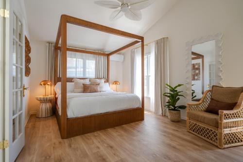 a bedroom with a canopy bed and a chair at Coastal Chateau Cottages in Ocean City