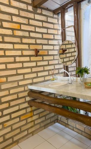 a bathroom with a sink and a brick wall at Pousada Ventoria in Canguaretama