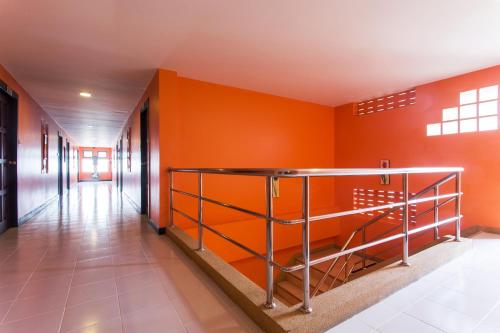 a hallway with orange walls and a metal railing at Chaweng Budget Hotel in Chaweng