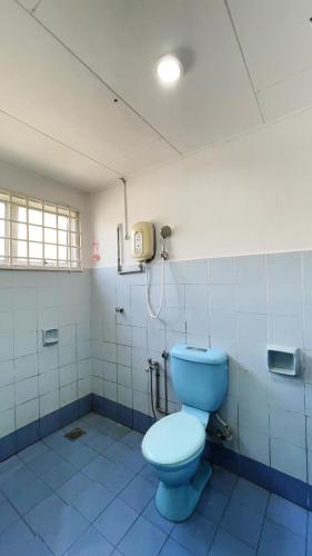 a bathroom with a blue toilet and a phone at PD Best Homestay in Port Dickson