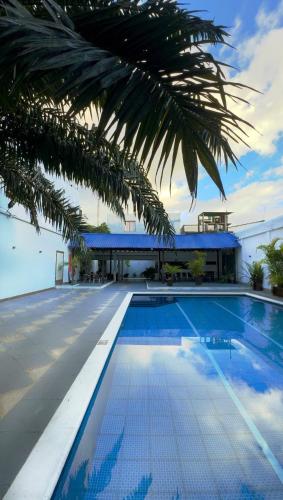 a swimming pool with a palm tree next to a building at Hotel Amazonas Real in Leticia